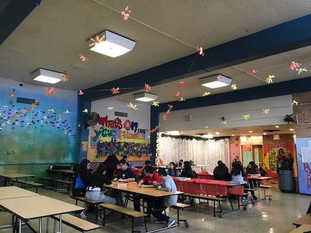 lunchroom with colorful murals and paper birds hanging from ceiling
