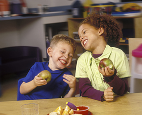 Two kids eating apples
