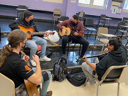 Students siting in a circle at a guitar lesson